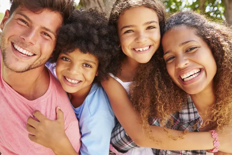 Smiling family of four in their backyard.